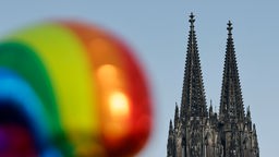 Ein Ballon in Regenbogenfarben neben dem Kölner Dom beim Christopher Street Day 2023 in Köln