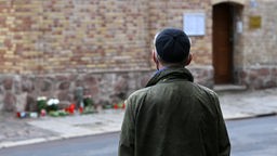  Ein Mann steht während der Schweigeminute 12:01 Uhr zum Gedenken der Opfer des Terroranschlags von Halle/Saale vor der Synagoge.