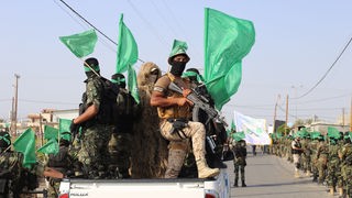 Hamas-Terroristen ziehen im Juli 2017 mit wehenden Fahnen durch Chan Junis im südlichen Gazastreifen