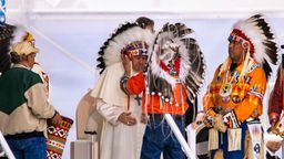 Papst Franziskus wird während seiner "Bußwahllfahrt" durch Kanada in Maskwacis von den Häuptlingen der großen Ureinwohnerstämme empfangen und erhält einen Federschmuck.