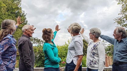 Die Trauerbegleiterinnen und Trauerbegleiter von Wolkenschieber e.V. recken der Wolkendecke die Hände entgegen