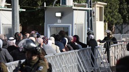 Eine dichtgedrängte Gruppe von Muslimen steht am 22.03.2024 zwischen Eisengittern vor einer Polizeikontrolle in Jerusalem