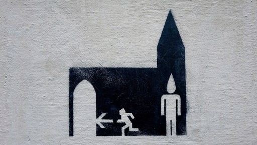 Ein Graffiti an einer Bonner Hauswand zeigt ein Piktogramm-Männchen, das aus einer Kirche rennt