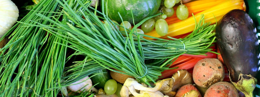 Das Beitragsbild des Dok 5 Feature "Einmal gesund und günstig bitte! Mittagstisch in Kita und Schule" zeigt verschiedenes, frisches Gemüse und Obst in einer Kiste