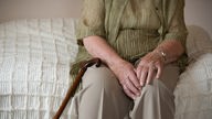 Das Beitragsbild des Dok5 Feature "Einsamkeit" zeigt eine ältere Frau auf dem Bett sitzend.