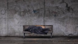 Das Beitragsbild des Dok5 "Angst haben fast alle - Gewalt im Leben von Obdachlosen" zeigt einen schlafenden Obdachlosen auf einer Bank in Berlin.
