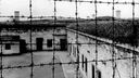 Blick durch Stacheldraht auf die Gebäude des 1941 von der SS errichteten Konzentrationslagers im tschechischen Theresienstadt. 