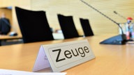 Das Beitragsbild des Dok5 "Vom Verschwinden – Leben im Zeugenschutzprogramm" zeigt ein Schild mit der Aufschrift "Zeuge" im Gerichtssaal in Erfurt. 