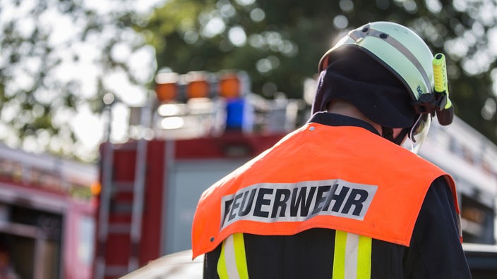 Das Beitragsbild des Dok5 "Notfall Feuerwehr" zeigt einen Feuerwehrmann von hinten mit gesenktem kopf. 