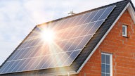 Das Beitragsfoto zeigt ein Einfamilienhaus mit Solarpaneelen auf dem Dach 