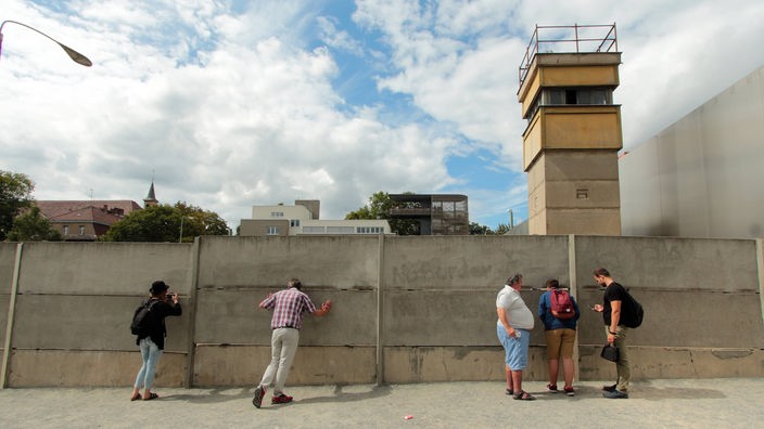 Gedenkstätte Bernauer Straße an der ehemaligen Mauer in Berlin, Deutschland: Besucher betrachten den Wachturm und Todesstreifen.