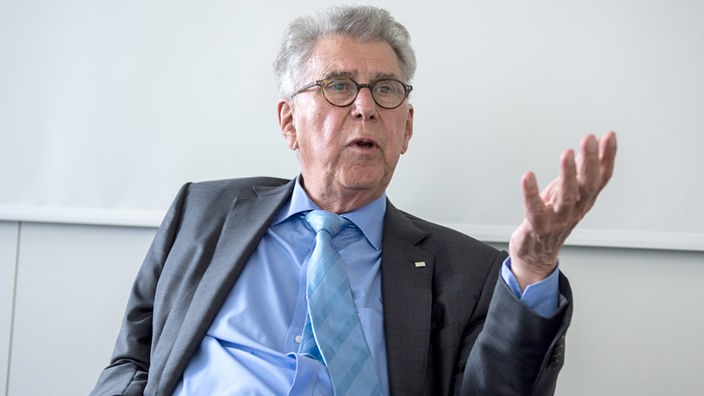 Heinz Dürr, ehemaliger Bahn-Chef sitzt an einem Tisch