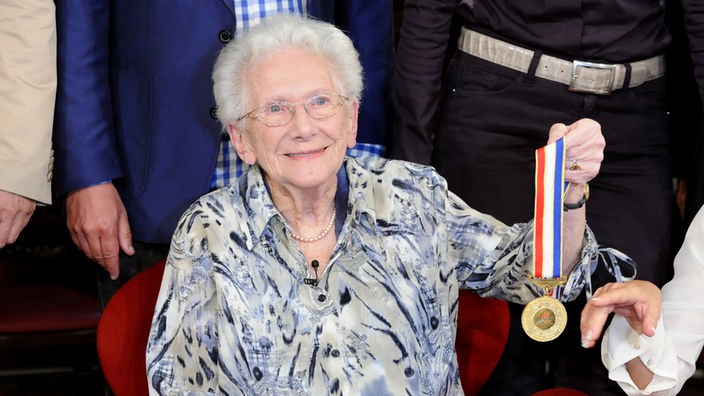  Inge-Brigitte Herrmann, älteste aktive Tennisspielerin hält Goldmedaille in der Hand