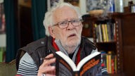 Der Krimibuchautor Jacques Berndorf alias Michael Preute posiert am 29.03.2016 im Café Sherlock in Hillesheim in der Eifel bei einem Pressegespräch zu seinem 80. Geburtstag mit seinem neuesten Buch "Magnetfeld des Bösen".