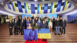 Wolodymyr Selenskyj,  Ursula von der Leyen und Denys Schmyhal  halten eine europäische und eine ukrainische Fahne während eines Gruppenfotos nach dem EU-Ukraine-Gipfel, 02.02.2023.