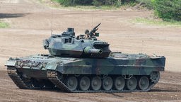 Bei einer Vorführung der Very High Readiness Joint Task Force (VJTF) fährt ein Kampfpanzer Leopard 2 auf einem Übungsfeld.