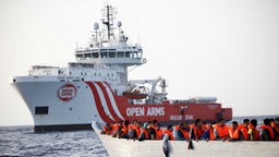 Migranten warten in einem Boot während einer Such- und Rettungsaktion im zentralen Mittelmeer, 17.08.2022.