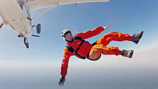 Fallschirmspringer springt aus  Flugzeug