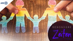 Ein Scherenschnitt in Regenbogenfarben zeigt eine queere Familie