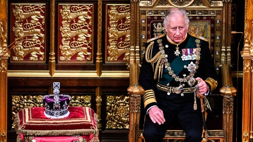 Der damalige Prinz Charles von Großbritannien sitzt zur Eröffnung des Parlaments im House of Lords am 10.05.2022 neben der Imperial State Crown auf seinem Platz.
