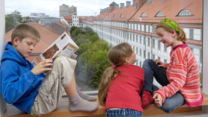 Kinder sitzen im einem Gebäude der Franckeschen Stiftungen auf dem Fensterbrett