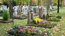 Ordentlich gepflegte und bepflanzte Gräber mit Herbstpflanzen auf dem Friedhof in Vaterstetten