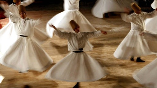 Tanzende Derwische treten in der Tanzhalle des Mevlana Mausoleums auf. In Konya starb am 17.12.1273 der Gründer der Mevlevi Sufi-Bruderschaft, der Poet Mevlana Jalal al-din Rumi.