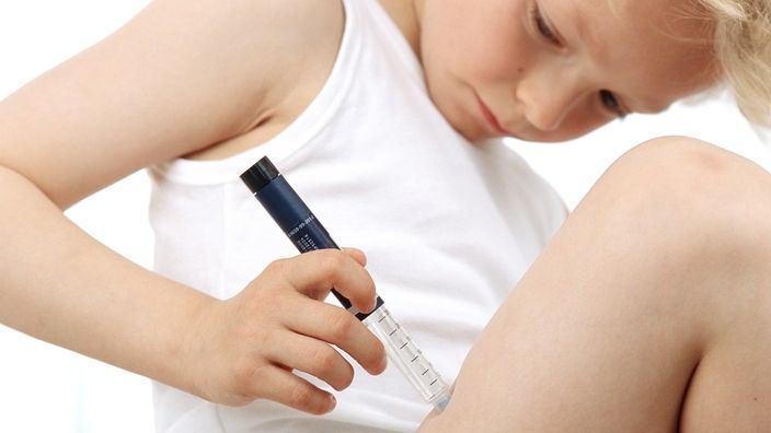 Ein Kind spritzt sich Insulin in den Oberschenkel.