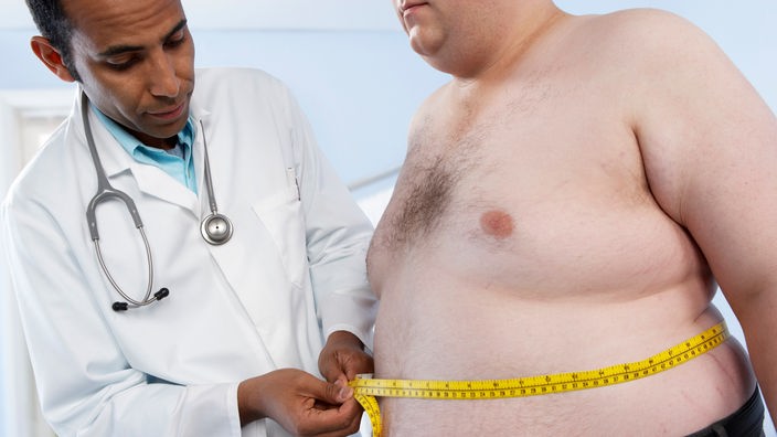 Arzt misst Bauchumfang eines übergewichtigen Patienten