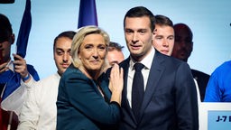 Marine Le Pen und Jordan Bardella vom Rassemblement National in Frankreich stehen gemeinsam auf der Bühne. 