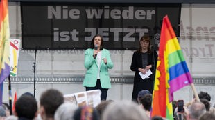 Katrin-Göring-Eckardt und Katja Meier (beide Bündnis90/Die Grünen), auf der Bühne bei einer Kundgebeung im Rahmen einer Demo auf dem Pohlandplatz. Hinter ihnen ein Transparent mit der Aufschrift "Nie wieder ist jetzt."