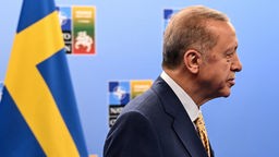 Recep Tayyip Erdogan, Präsident der Türkei, auf dem NATO-Gipfel in Vilnius. Im Hintergrund die Flagge Schwedens. 