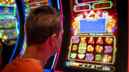 junger Mann an einem Glücksspiel-Automat