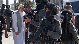 Israelische Sicherheitskräfte stehen Wache zwischen palästinensischen Muslimen