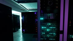 LEDs leuchten an Servertürmen in einem dunklen Rechenzentrum