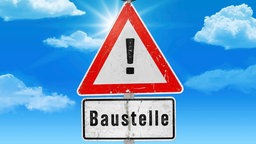 Warnschild "Baustelle" vor blauem Himmel.