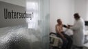 Arzt misst bei einem Patienen Blutdruck in einem Behandlungszimmer, Symbolbild