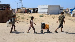 Kinder holen im Gebiet al-Mawasi in der Stadt Chan Junis im südlichen Gazastreifen Wasser.