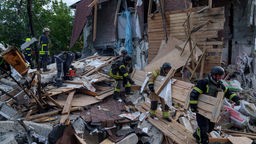 Rettungskräfte räumen die Trümmer eines durch einen russischen Luftangriff zerstörten Gebäudes (10.06.2024, Ukraine, Charkiw)