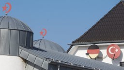 Moschee mit Satelittenschüsseln im Muster deutscher und türkischer Fahnen sowie Halbmonden auf dem Dach
