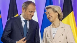 Polens Regierungschef Donald Tusk und EU-Kommissionspräsidentin Ursula von der Leyen lächeln einander an. 