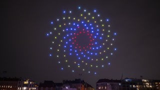 Leuchtende Drohnen formen am Himmel ein Muster. Symbolbild, Archivbild: 27.11.2023