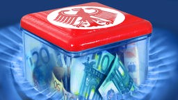 Symbolbild: In einem Gasring steht ein durchsichtiger Behälter mit Geld, der  rote Deckel ist mit dem Bundesadler bedruckt.