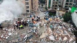 Notfallteams suchen nach Menschen in einem zerstörten Gebäude (06.02.2023, Türkei, Kahramanmaras)