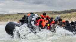 Migranten besteigen das Schlauchboot eines Schmugglers und versuchen, den Ärmelkanal zu überqueren (30.10.2024, Saint-Étienne-Au-Mont). 