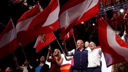 Mitglieder der FPÖ schwenken österreichische Nationalflaggen bei der Wahlkampfverantaltung am 07.09.24