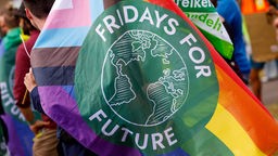 "Fridays for Future" Emblem auf einer Regenbogenfahne