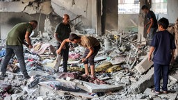 Menschen inspizieren die Zerstörung nach dem israelischen Bombardement der palästinensischen Muscat Governmental School (2. Oktober 2024, Gaza-Stadt).