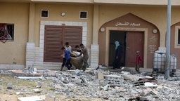 Palästinenser fliehen mit ihren Besitztürmern aus einem Haus im Gaza-Streifen.