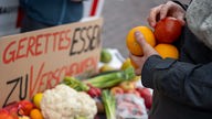 Obst und Gemüse vor einem Schild "Gerettetes Essen zu verschenken" (Aktion der Initiative "Aufstand der letzten Generation" 18.02.2022)